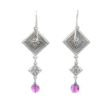 Meet La Dolce Vita Diagonal Drop Multi-Color Earrings by Firefly: Silver dangling accessories with a square design, handcrafted in Guatemala. They feature intricate patterns and a small purple bead, proudly celebrating fair-trade jewelry against a serene white background.