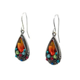 Explore the allure of Fireflys Elegant Drop Multi-Color Earrings, handcrafted in Guatemala. These teardrop-shaped gems boast an orange centerpiece framed by blue, green, and red stones, all set in hypoallergenic silver-toned metal for sensitive skin.
