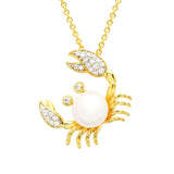 The Gold Vermeil Pearl Crab Necklace by Shanore features a pendant with a large central pearl, adorned with white cubic zirconia on the claws and eyes, elegantly suspended from a shimmering gold chain.
