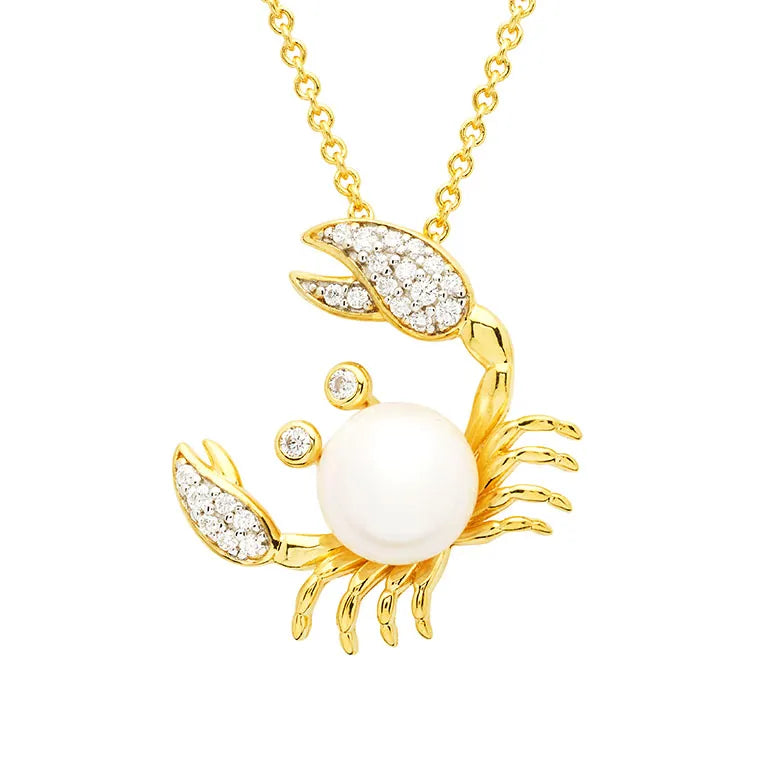 The Gold Vermeil Pearl Crab Necklace by Shanore features a pendant with a large central pearl, adorned with white cubic zirconia on the claws and eyes, elegantly suspended from a shimmering gold chain.
