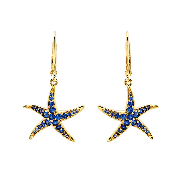 The Shanore Gold Vermeil Blue Sapphire Starfish Earrings- Ocean Jewelry are elegant gold starfish drop earrings with lab-grown sapphires on hooks, presented against a plain white background.