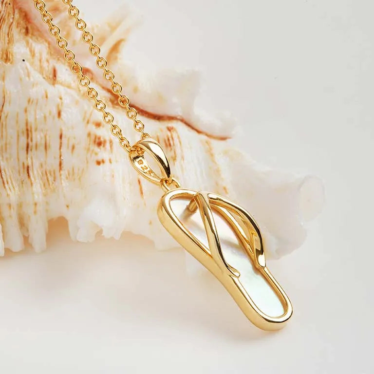 The Shanore Gold Vermeil Mother of Pearl Flip Flop Necklace features a sleek pendant design on a delicate chain. The textured shell background beautifully reflects light, enhancing its polished surface and adding elegance to any ensemble.