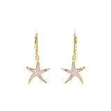 Shanores Gold Vermeil Starfish Earrings from the Ocean Jewelry collection, adorned with cubic zirconia and hanging from delicate hooks, capture the oceans allure. These 14k gold treasures radiate elegance against a pristine white backdrop.