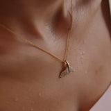 Close-up of a neck and upper chest, featuring Shanores Gold Vermeil Whale Tail Necklace - Ocean Jewelry. The skin glistens with water droplets, suggesting a fresh or dewy look.