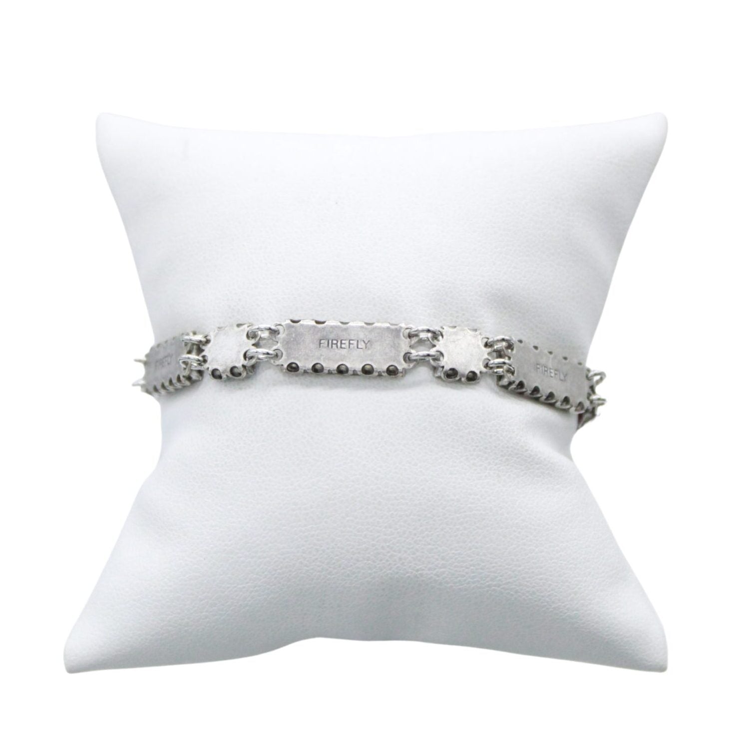 The Firefly Architectural Light Turquoise Bracelet features engraved rectangular links with smooth and embellished sections, showcasing exquisite craftsmanship. Crafted using fair-trade practices in Guatemala, its beautifully displayed on a white cushion for an elegant presentation.