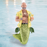 The Key Lime Daddy Ornament by December Diamonds features a bald merman with a beard, wearing a yellow shirt with green designs. He sports a sparkling green mermaid tail and holds a cocktail glass, complete with leafy waist accessories and set against a watery backdrop for whimsical holiday decor.
