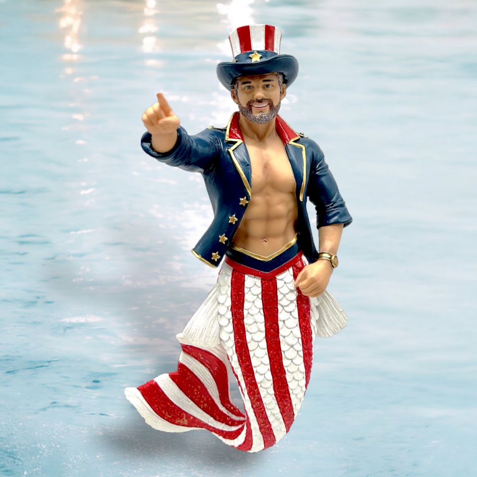 The Guncle Sam Ornament by December Diamonds features a merman with a muscular upper body, U.S. flag-patterned tail, and a starry top hat. His shimmering gold-trimmed jacket adds flair to your holiday decor.