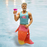 The December Diamonds Palm Springs Ornament features a muscular older merman with gray hair and beard, wearing a blue Palm Springs tank top. His vibrant pink and orange mermaid tail sparkles as he holds a pink cocktail glass, set against a watery backdrop—ideal for holiday decor.