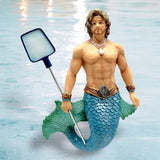 The Cabana Rent Boy Ornament by December Diamonds features a merman with a muscular torso and turquoise scaly tail, holding a pool net. Adorned with bracelets and a shell necklace, he stands in water, perfect for holiday decor.