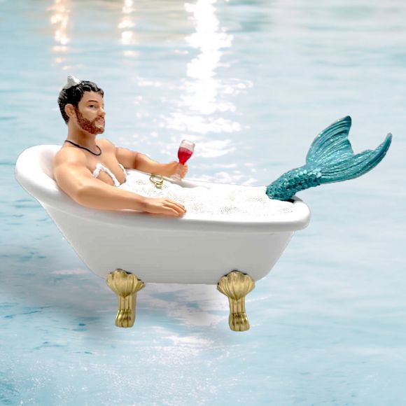 The Mr Bubbles Ornament by December Diamonds features a bearded merman lounging in a bubble-filled clawfoot tub, holding red wine. His turquoise tail and necklace complement this whimsical holiday decor.