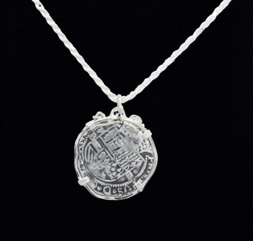 The Treasure Shoppe Inc.s Large Octopus Coin-Atocha Shipwreck Pendant is set in a detailed sterling silver bezel, evoking historical Atocha coins, displayed on a twisted silver chain against a black background to highlight its intricate design.