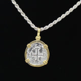 The Treasure Shoppe Inc.s Gold Plated Reale/Oblong Coin-Atocha Shipwreck Pendant features a historic Atocha coin with a cross and markings, elegantly hanging from a twisted sterling silver chain against a black background, exuding timeless charm.