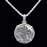 The Treasure Shoppe Inc.s 500 Museum Replica Coin pendant, featuring Atocha Shipwreck design, is set in a four-pronged sterling silver setting. The antique-style piece hangs elegantly from a twisted chain against a black backdrop.