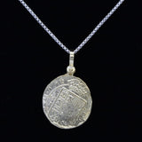 The Treasure Shoppe Inc.s Gold Plated Round Escudo Coin pendant evokes ancient allure with its intricately detailed, weathered design inspired by Atocha Shipwreck coins.