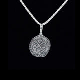 The Treasure Shoppe Inc. offers the Lima 8 Escudo Coin - Atocha Shipwreck Coins pendant only, featuring a sterling silver bezel encasing an ancient coin with intricate engravings and a central cross pattern, reminiscent of treasures from Nuestra Señora de Atocha.