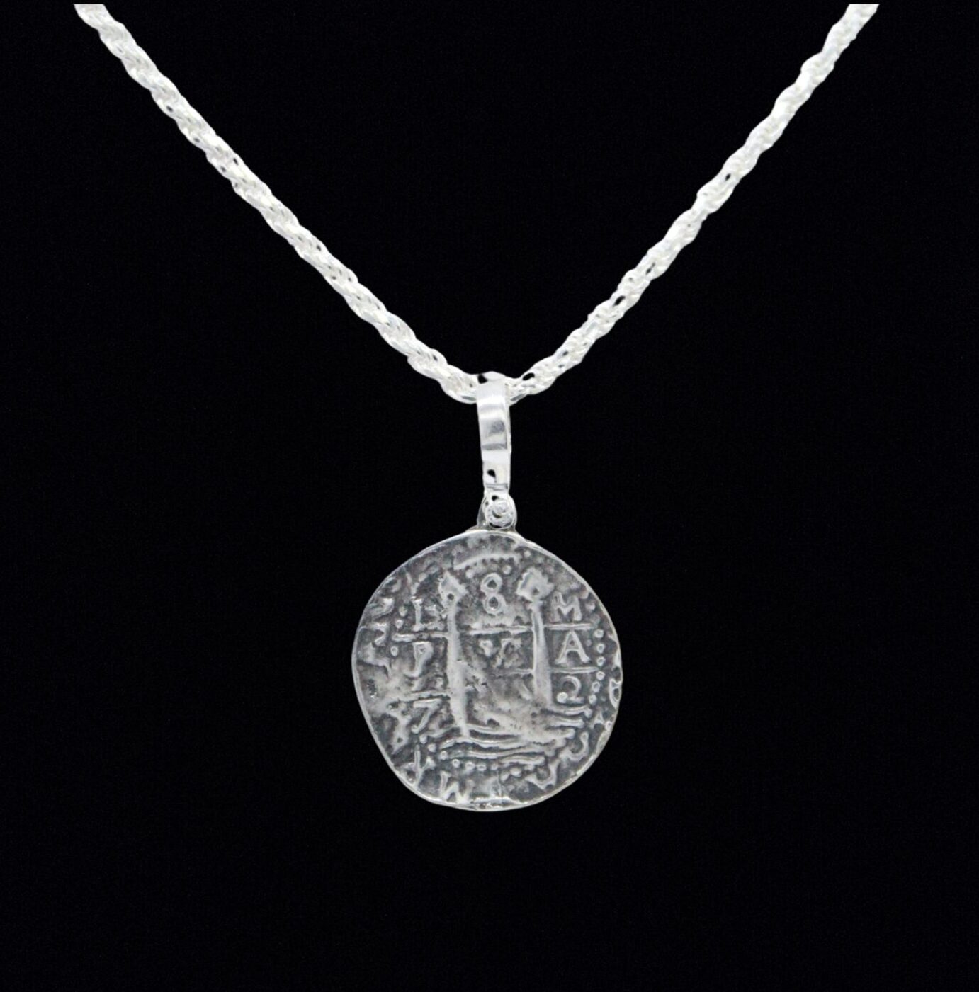 A sterling silver necklace with a twisted chain and circular pendant echoes the Lima 8 Escudo Coins design with an ancient coin motif on a black background, from Lima 8 Escudo Coin - Atocha Shipwreck Coins (Pendant Only) by The Treasure Shoppe Inc.