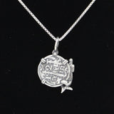 The Treasure Shoppe Inc.s Medium Mermaid Coin from the Atocha Shipwreck Coins collection features a sterling silver bezel with intricate engravings and a mermaid figure. This pendant elegantly hangs on a chain against a black background.