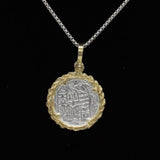 The Treasure Shoppe Inc.s Gold Plated Rope Bezel Coin, inspired by Atocha Shipwreck Coins, features intricate designs on a black background with a gold plated rope bezel.