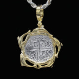The Treasure Shoppe Inc.s Gold Plated Dolphin Frame Coin—Atocha Shipwreck Coins (Pendant Only) features a historic coin framed with elegant vine-like gold swirls, reflecting maritime history. Suspend from your favorite chain to capture its allure against any backdrop.