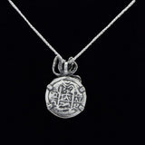 The Treasure Shoppe Inc.s Medium Antique Octopus Coin pendant, inspired by Atocha Shipwreck Coins, features an engraved design on sterling silver, displayed elegantly on a delicate chain against a black background.