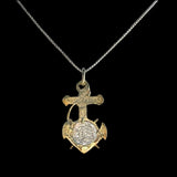 The Treasure Shoppe Inc.s Gold Plated Anchor Coin- Atocha Shipwreck Coins pendant features a cross and anchor design with an intricate circular element, reminiscent of Atocha coins, elegantly showcased on a delicate chain against a black background.