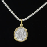 The Treasure Shoppe Inc. presents the Gold Plated Reale/Oblong Coin - Atocha Shipwreck Coins pendant, featuring an ancient coin in a gold-plated frame with four prongs and intricate, faded carvings set against a black background.