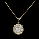 The Treasure Shoppe Inc.s Gold Plated Round Reale Coin-Atocha Shipwreck Pendant features engraved symbols and a cross pattern, secured by four prongs. Its reminiscent of an Atocha coin and displayed against a black background.