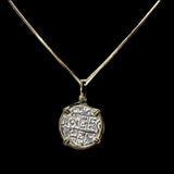 A Gold Plated Round Reale Coin-Atocha Shipwreck Coin pendant from The Treasure Shoppe Inc., with an ancient design and intricate patterns, is elegantly showcased against a solid black background.