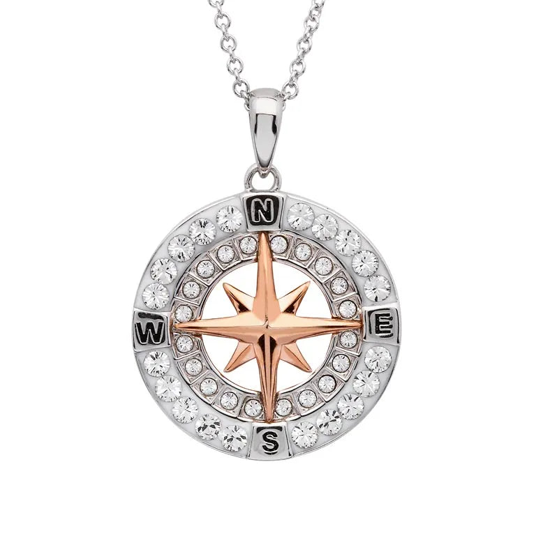 The Shanore Swarovski Crystals Rose Gold Compass Necklace from Ocean Jewelry features a round silver pendant with clear Swarovski crystals, and a rose gold compass star at its center, adorned with cardinal points N, E, S, and W surrounded by shimmering stones.