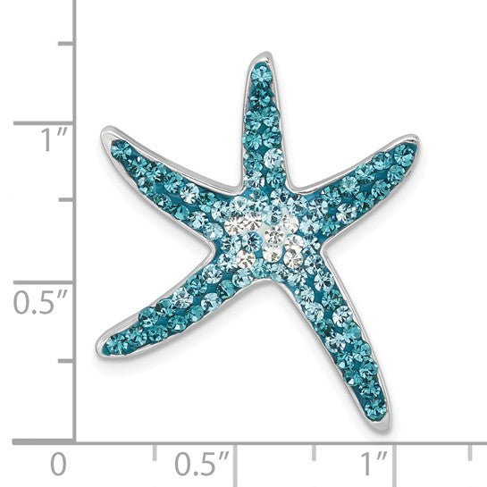 The Crystal Blue Starfish Pendant by Presco/Quality Gold, adorned with blue and white crystals, is displayed on a grid with inch markings for scale, showing it measures approximately 1 inch wide.