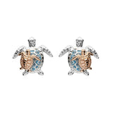The Shanore Swarovski Crystals Turtle & Baby Stud Earrings feature two turtle-shaped studs in sterling silver with gold accents. Their blue-detailed shells and sparkling crystals stand out against a white backdrop, exuding elegance.