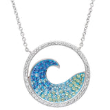 The Shanore Swarovski Crystals Blue Wave Necklace-Ocean Jewelry features a sterling silver wave pendant with blue and green gemstones, accentuated by clear Swarovski Crystals on the circle, elegantly hanging from a delicate chain.