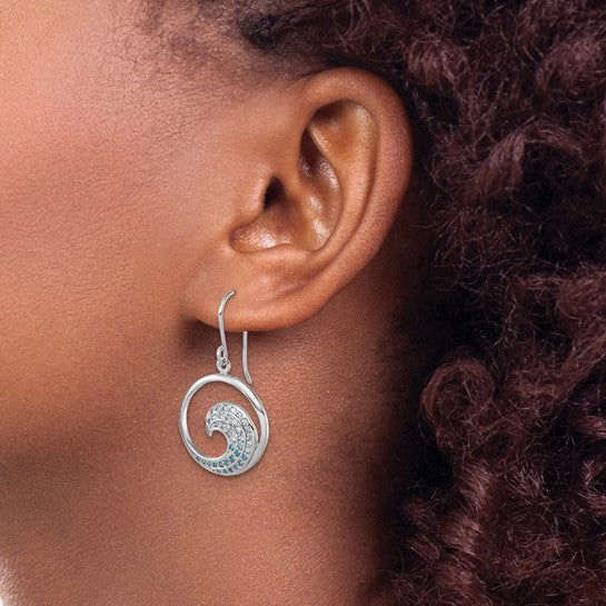 A close-up of a person’s ear with curly hair wearing Presco/Quality Gold Crystal Wave Blue CZs Earrings, sterling silver spirals with an intricate wave-like design.