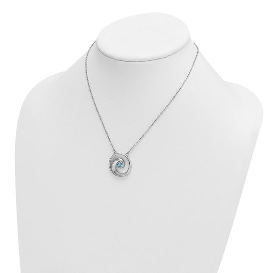 The Presco/Quality Gold Crystal Wave Aqua Crystal Pendant is a silver necklace with a circular pendant featuring a small blue crystal, displayed on a white jewelry bust.