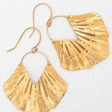 Introducing the Gold Ariel Earrings from Holly Yashi, featuring exquisite gold-plated, fan-shaped pendants with flat triangular designs. The matte finish and subtle reflections enhance their elegant and unique allure.