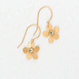 The Plumeria Drop Gold Earrings by Holly Yashi feature textured, flower-shaped petals with a shiny center—feminine jewelry perfect for garden parties. Displayed on a white background.