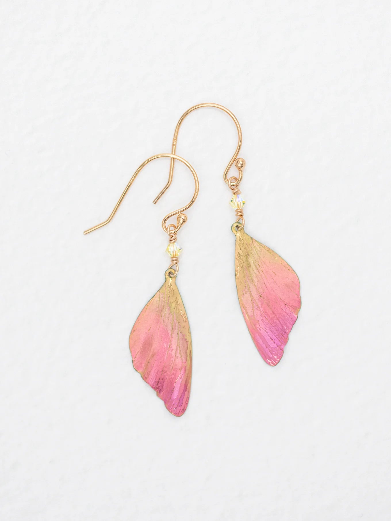 The Special Edition Flutterby Pink Earrings by Holly Yashi feature gold hooks and pink, butterfly wing-shaped charms with gold accents—ideal gold earrings to support cancer awareness. Shown on a white background.