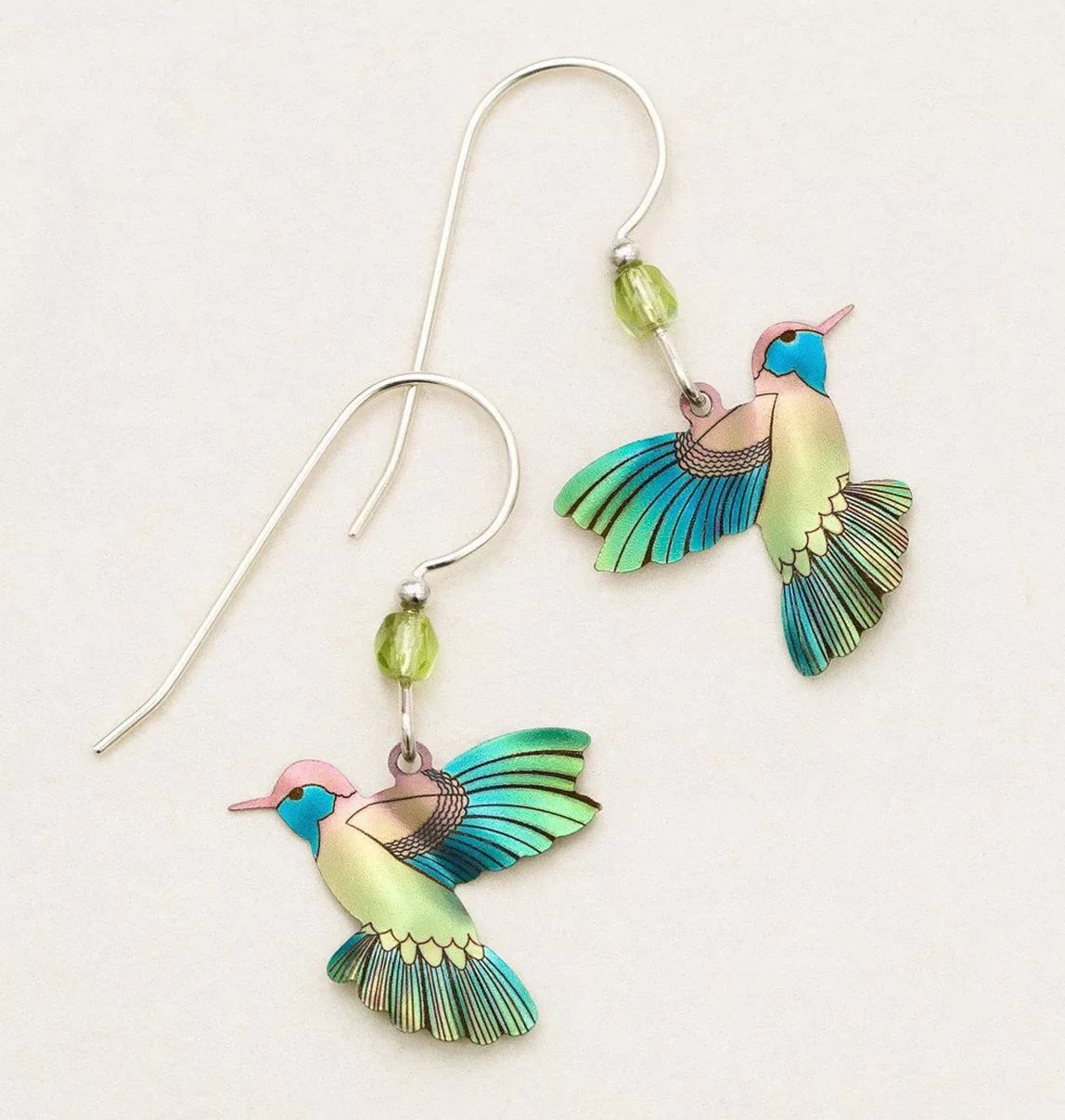 Island Green Picaflor Earrings by Holly Yashi feature vibrant hummingbirds with hand-painted niobium wings in green, blue, and pink hues, complemented by a green bead on sterling silver French wires.