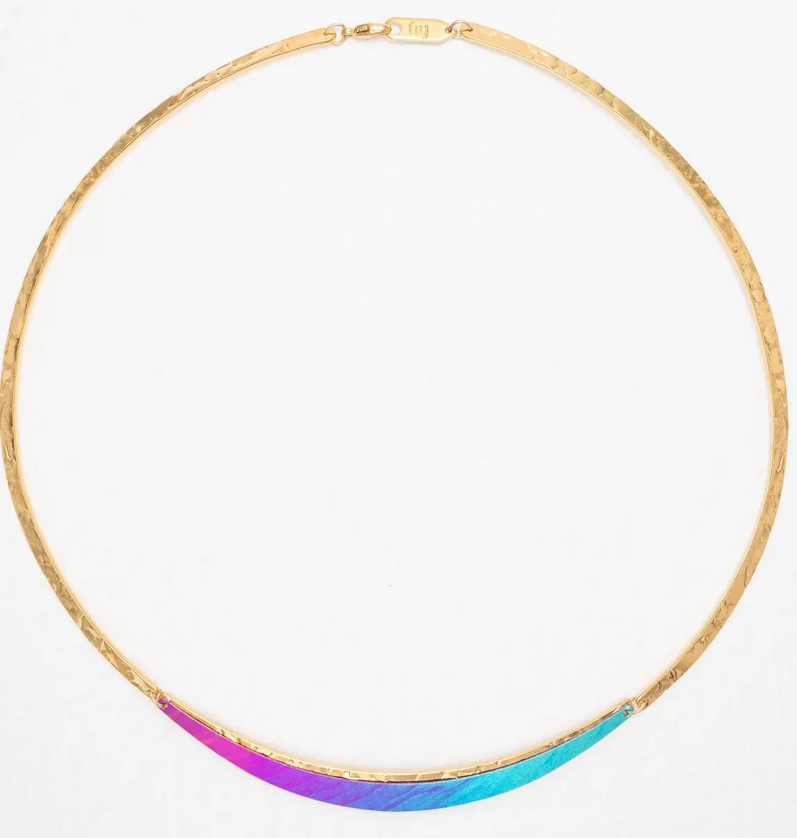 The Gianna Calypso Collar Necklace by Holly Yashi is a thin gold piece with a textured hand-hammered pendant, displaying a stunning purple-to-blue gradient. Hypo-allergenic and elegant, its perfect for sensitive skin.