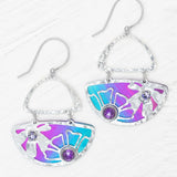 The Demi Calypso Earrings by Holly Yashi are hammered silver drop earrings with blue and purple enamel fan shapes, each adorned with two round purple gemstones and finished with sterling silver posts.