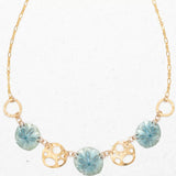 Introducing the Sage Oceana Necklace by Holly Yashi: a gold treasure with alternating blue starfish-patterned pendants and openwork circles like gold-plated shells. The delicate chains small links create an elegant, ocean-inspired ensemble.