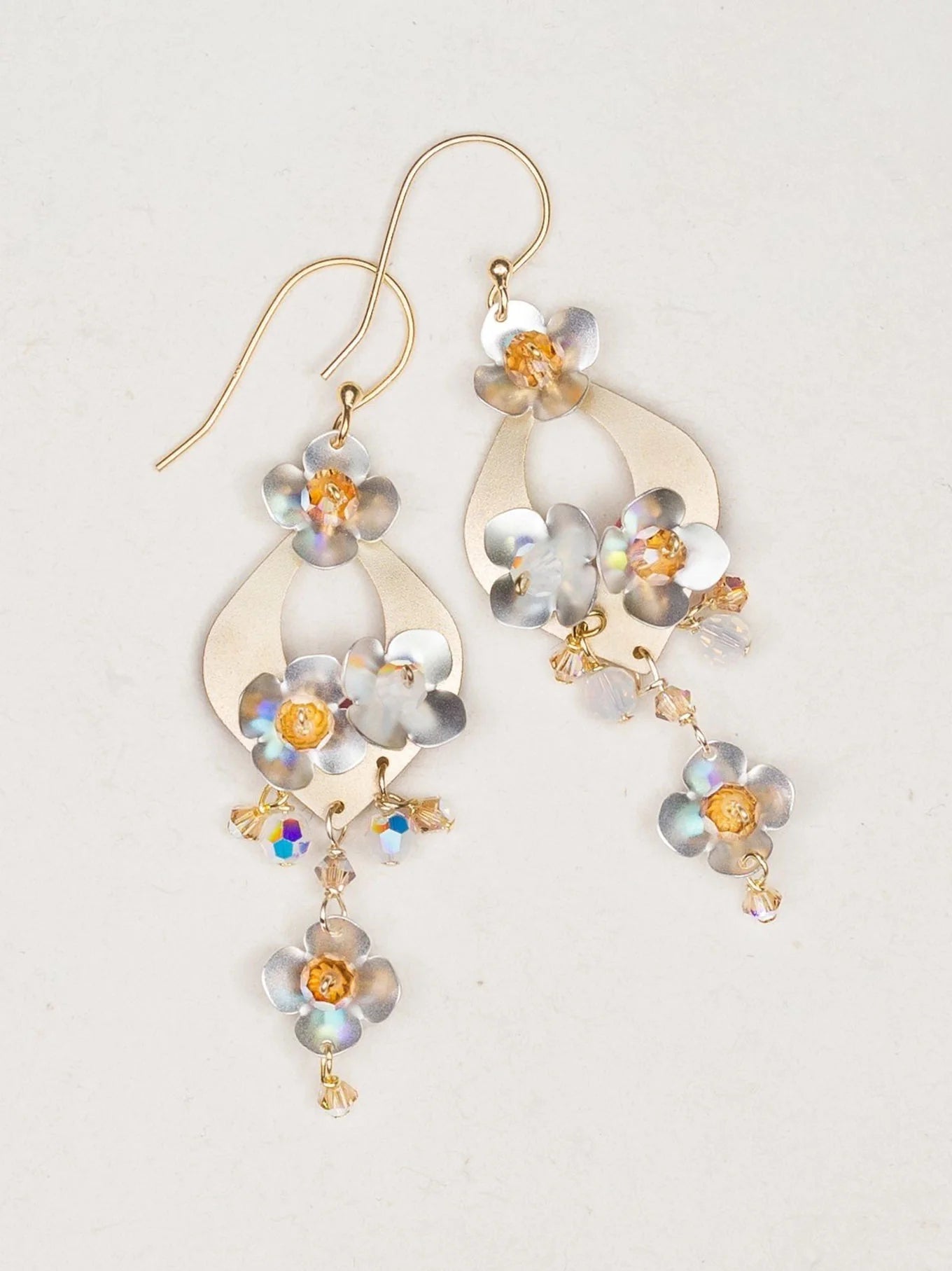 Holly Yashi’s Hawaiian Wedding Gold/Silver Earrings feature gold hooks, metallic floral shapes, iridescent beads, and shimmering flower accents—perfect for a gorgeous wedding look.