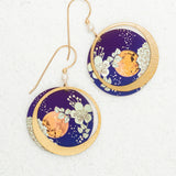 Luna Earrings/Blue Moon by Holly Yashi: Circular earrings with gold hooks, featuring a gold crescent moon over deep blue with white floral designs and an orange accent. Hypo-allergenic niobium—safe for sensitive ears.
