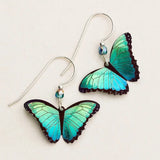 Introducing Holly Yashis Green Flash Bella Butterfly Earrings, featuring turquoise-winged butterflies with dark outlines, silver hooks, and a small blue bead for niobium elegance.