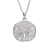 The Shanore Swarovski Crystals White Sand Dollar Necklace features a pendant resembling its namesake, adorned with tiny Swarovski crystals. The central star pattern glistens beautifully on a sterling silver chain, exemplifying elegant ocean jewelry.