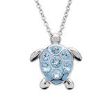 The Shanore Swarovski Crystals Medium Turtle Aqua Necklace features a sterling silver pendant with a light blue shell adorned with seven sparkling Swarovski crystals, hanging from a sleek chain for an elegant and playful design.