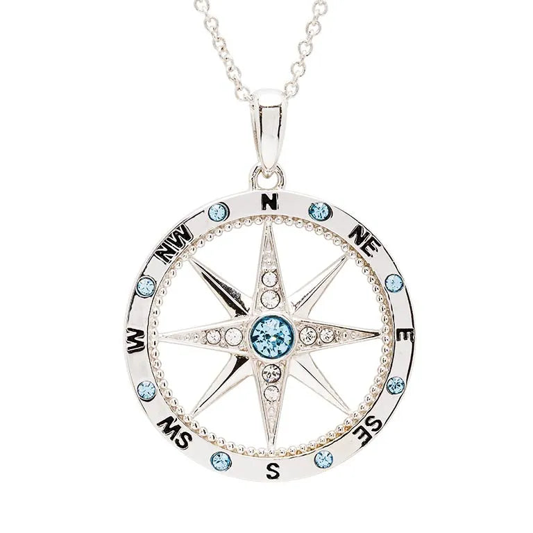 The Shanore Swarovski Crystals Aqua and White Compass Necklace - Ocean Jewelry is a sterling silver pendant adorned with shimmering crystals. It features eight directional points labeled N, NE, E, SE, S, SW, W, NW with blue gems embellishing the points and outer circle for a stunning look.