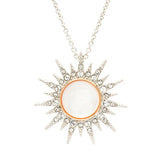 The Shanore Swarovski Crystals Mother of Pearl Rose Gold Sun Necklace features a sterling silver sun pendant with a Mother of Pearl center, encircled by gold and silver spikes adorned with Swarovski crystals for an elegant design.