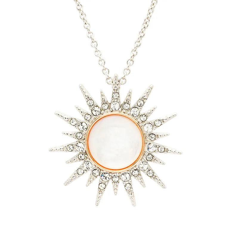 The Shanore Swarovski Crystals Mother of Pearl Rose Gold Sun Necklace features a sterling silver sun pendant with a Mother of Pearl center, encircled by gold and silver spikes adorned with Swarovski crystals for an elegant design.
