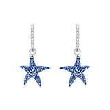 These elegant Shanore earrings are sterling silver hoops with Swarovski crystal and stone-encrusted starfish charms, designed as blue sapphire ocean-inspired jewelry.